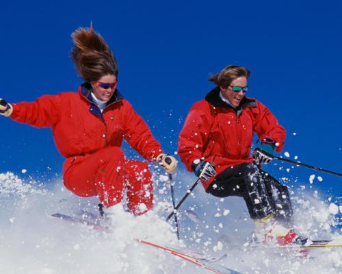 two people are skiing down a snow covered slope at Residence Nube D'Argento in Sestriere