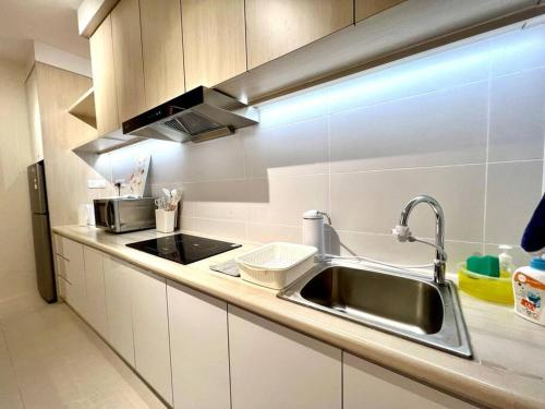 クチンにあるElegant Riverine Diamond Homestay With Poolのシンクとカウンタートップのあるキッチン