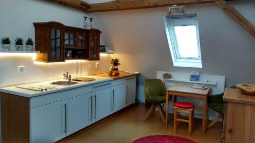 a kitchen with a sink and a table and a window at Ferienwohnung am Weidachbach in Volkach