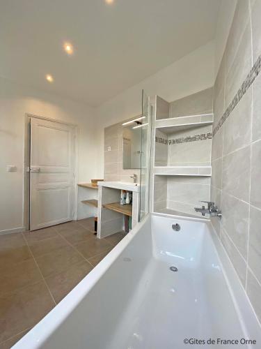 une salle de bain blanche avec une baignoire et un lavabo dans l'établissement Gîte de la Poste 6, à Saint-Fraimbault-sur-Pisse