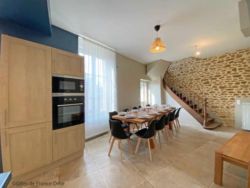 une cuisine avec une table avec des verres à vin dessus dans l'établissement Gîte de la Poste 6, à Saint-Fraimbault-sur-Pisse