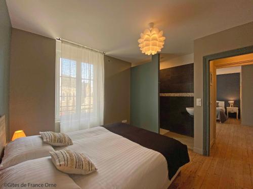 une chambre avec un grand lit et une salle de bain dans l'établissement Gîte de la Poste 6, à Saint-Fraimbault-sur-Pisse