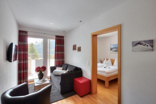 a living room with a couch and a bed and a mirror at Hölderle Damüls in Damuls