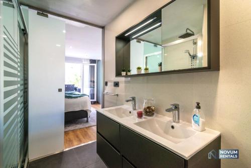 a bathroom with a sink and a mirror at Luxurious Beachside in the Heart of Puente Romano in Marbella