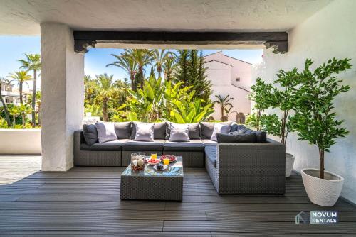 a living room with a couch on a patio at Luxurious Beachside in the Heart of Puente Romano in Marbella