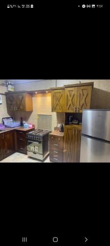 a kitchen with wooden cabinets and a stainless steel refrigerator at Naaser in Cairo
