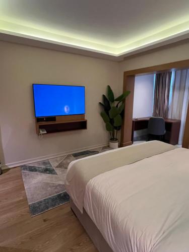 a bedroom with a bed and a flat screen tv at مخصص للعوائل فقط Four Elements in Cairo