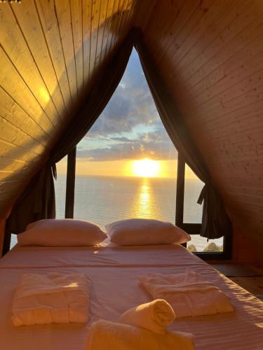 a bed in a room with a view of the ocean at Panorama Sarpi in Batumi