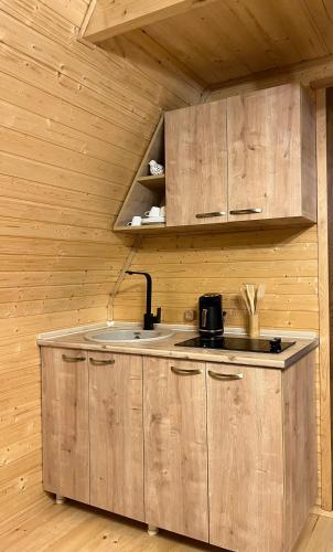 a kitchen with wooden cabinets and a sink at Panorama Sarpi in Batumi