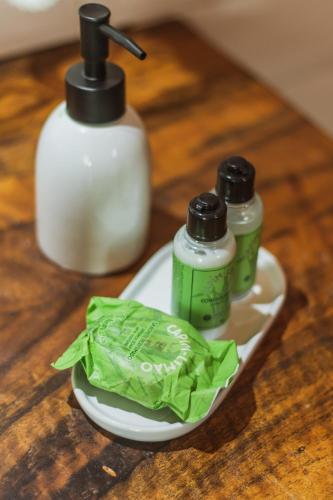 a table with two bottles of soap and a plate of lettuce at Pousada Canto da Nascente in Monte Verde
