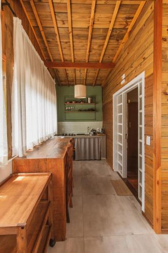 a kitchen with wooden walls and a wooden ceiling at Pousada Canto da Nascente in Monte Verde