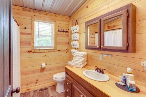 ein Badezimmer mit einem Waschbecken und einem WC in einem Blockhaus in der Unterkunft Melbourne Home with Fire Pit on the White River! in Melbourne