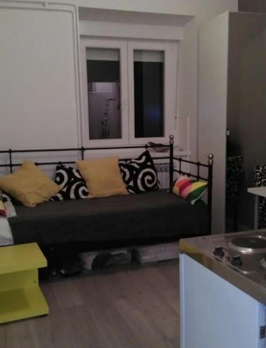 uma sala de estar com uma cama com almofadas e uma janela em Habitat em Senaki