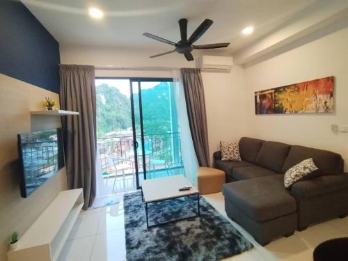 a living room with a couch and a ceiling fan at Sunway Onsen 4-5pax in Kampong Batu Lapan