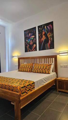 a bed in a room with paintings on the wall at Starfish apartment in Paje