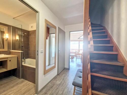 Un escalier mène à une salle de bains pourvue d'un lavabo et d'une baignoire. dans l'établissement Confortable Studio + Mezzanine avec Balcon au Centre de Val d'Isère - 2/4 Personnes - FR-1-518-133, à Val dʼIsère