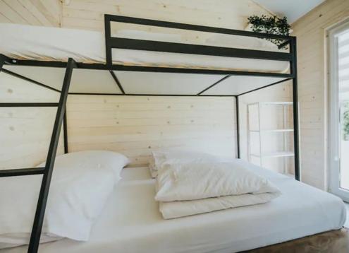 1 dormitorio con litera con sábanas y almohadas blancas en Your Comfort en Zestafoni