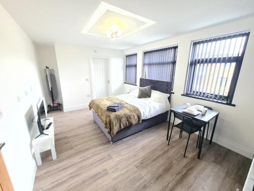 sypialnia z łóżkiem, stołem i oknami w obiekcie Homestay by BIC Legends 2 w mieście Batley Carr