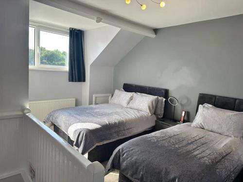 a bedroom with two beds and a window at Spacious 3 bed house in Wombwell in Wombwell