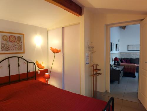 Schlafzimmer mit einem Bett mit einer roten Tagesdecke in der Unterkunft Bel Air -les Restanques in La Ciotat
