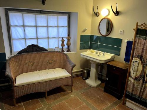baño con lavabo y silla junto a un espejo en appartement Terra Cotta, en Julienne