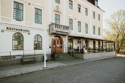 a large white building with a sign that readsrestricting at Hotell Vaxblekaregården in Eksjö