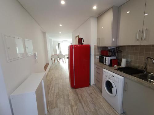 a kitchen with a red refrigerator and a washing machine at Tomarhousing - 37 Old Town in Tomar