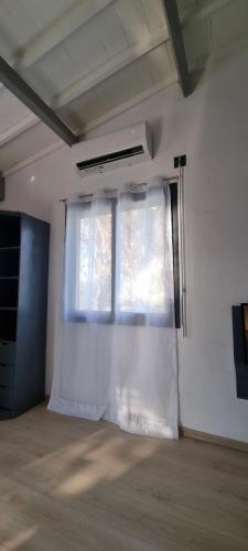 a white curtain in a room with a window at Flamingo résidence in Toliara