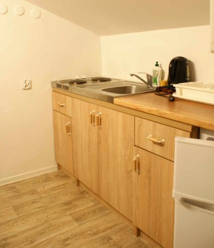 a kitchen with a sink and wooden cabinets at Domek w Karkonoszach Stary Eden in Karpacz