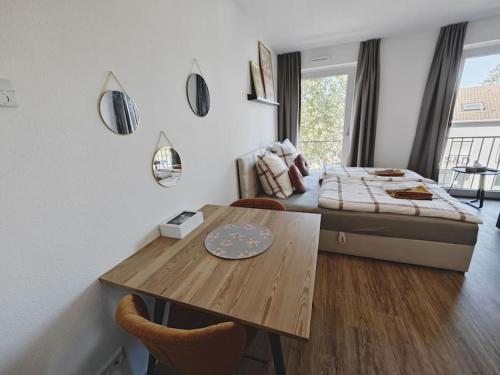 a bedroom with a bed and a table and a dining room at TiCasa HAPPY Zentral-Outlet-Parkplatz-Aufzug-SmartTV-Unique in Metzingen