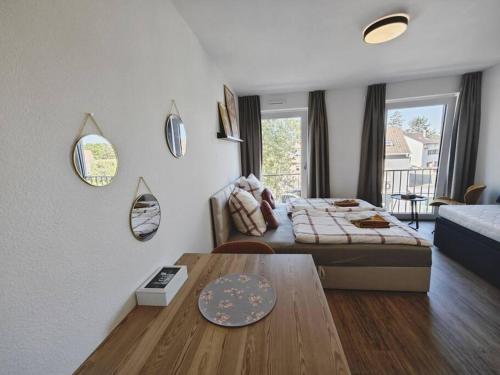 a bedroom with a bed and a table in a room at TiCasa HAPPY Zentral-Outlet-Parkplatz-Aufzug-SmartTV-Unique in Metzingen