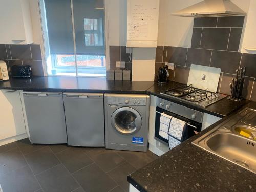 a kitchen with a washing machine and a sink at Sheffield City Centre - Westhill House Apartments in Sheffield