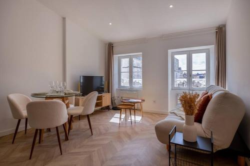 a living room with a couch and a table at La suite d'Orbigny en hyper centre in La Rochelle