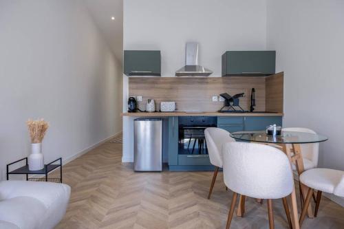 a living room with a table and white chairs at La suite d'Orbigny en hyper centre in La Rochelle