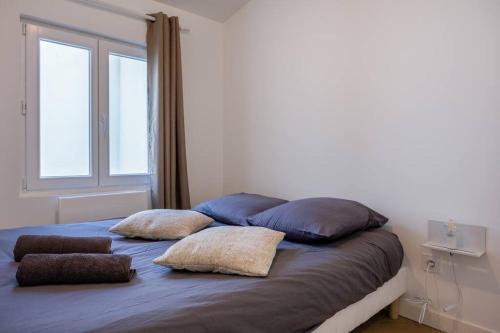 a bed with two pillows on it in a bedroom at La suite d'Orbigny en hyper centre in La Rochelle