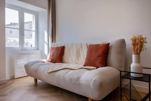 a white couch in a living room with a window at La suite d'Orbigny en hyper centre in La Rochelle