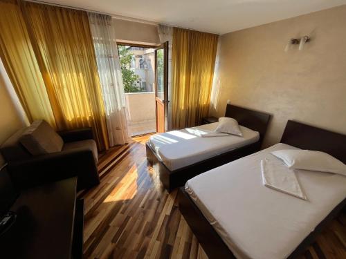 a hotel room with two beds and a window at Complex Ramiro in Suceava