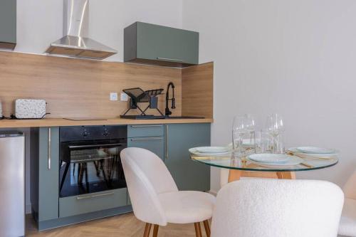 a kitchen with a table and two chairs and a counter at La suite d'Orbigny en hyper centre in La Rochelle