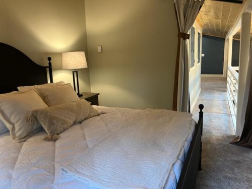 a bedroom with a large white bed and a hallway at Froggy Goggle Barn in Marathon