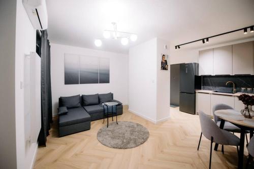 uma sala de estar com um sofá, uma mesa e uma cozinha em obywatelska apartament free parking em Lódź