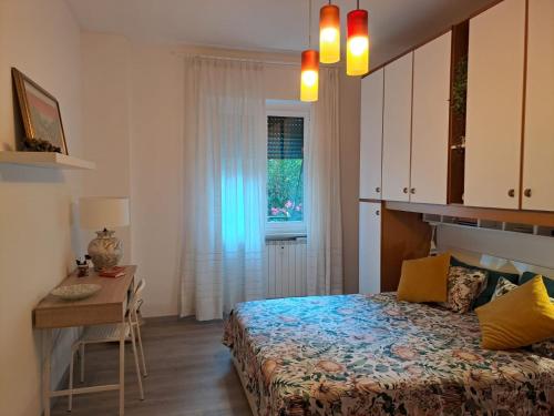 een slaapkamer met een bed, een bureau en een raam bij CasaRina Milano in Milaan
