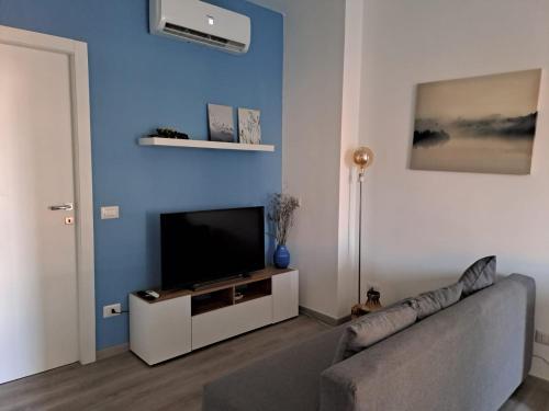 een woonkamer met een bank en een flatscreen-tv bij CasaRina Milano in Milaan