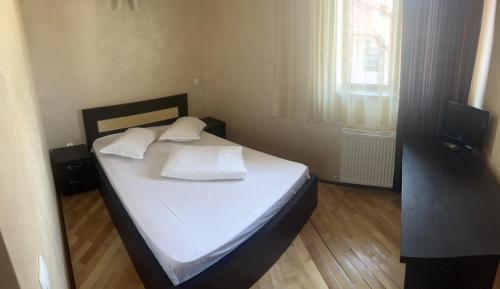 a bedroom with a bed with white sheets and pillows at Complex Ramiro in Suceava