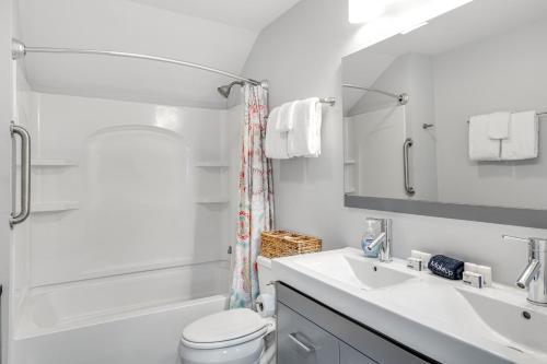 une salle de bain avec un lavabo, des toilettes et une douche dans l'établissement Lake Cruiser Cottage, à Manson
