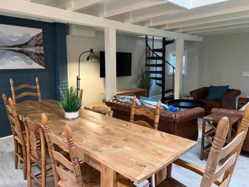 a dining room with a wooden table and chairs at Froggy Goggle Barn in Marathon