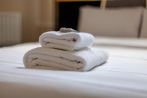 a stack of towels sitting on top of a bed at Spacious 1 BDR apt - 2min to Bond Str Station in London