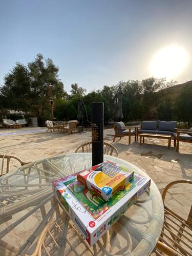 uma mesa de vidro com um livro em cima em منتجع جلامبنغ - Glamping Resort em Al Fawwāz