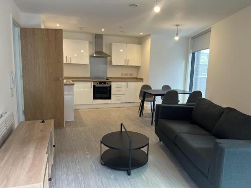 a living room with a couch and a table at Charming 2-Bed Apartment in Salford newly built in Manchester