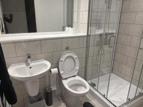 a bathroom with a toilet and a sink and a shower at Charming 2-Bed Apartment in Salford newly built in Manchester