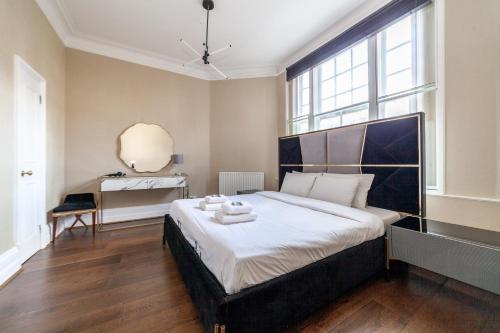 a bedroom with a large bed with a large window at Spacious 1 BDR apt - 2min to Bond Str Station in London
